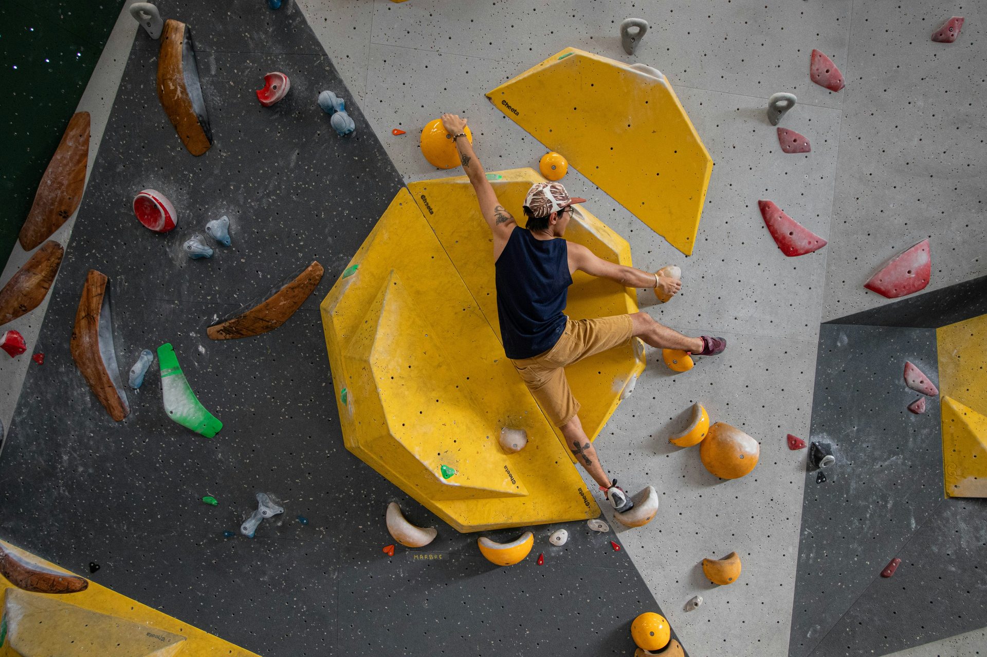Climber on yellow bouldering wall at Gravity House